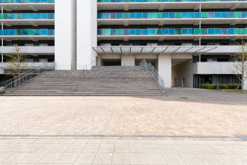 いちょう通り（北）：左右にいちょうが植栽された街の方が多く通るメインストリートに隣接するマンション入り口のデッキ階段